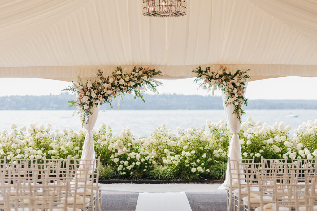 white tented lakeside wedding ceremony with florals and hydrangeas 